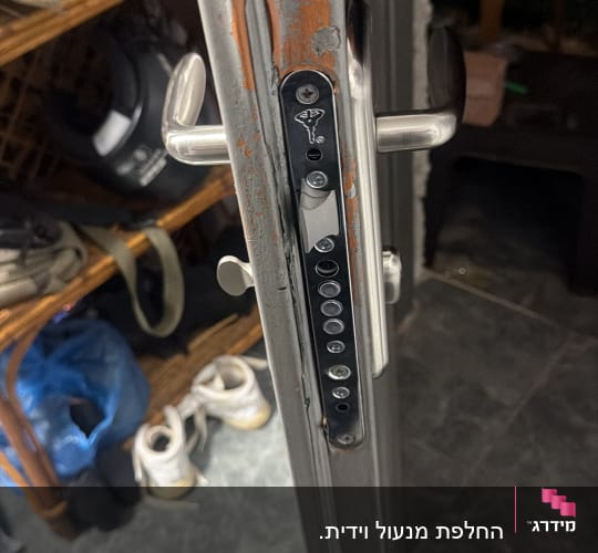 מנגנון מנעול וידית מותקנים בדופן דלת מתכת